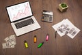 Computer desk with laptop and red arrow chart in screen Royalty Free Stock Photo