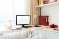 Computer display and office tools on desk in home. Desktop computer screen isolated. Modern creative workspace background.