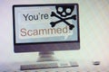 Computer displaying internet fraud and scam warning on screen