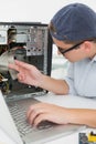 Computer engineer working on broken console with laptop Royalty Free Stock Photo
