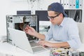 Computer engineer working on broken console with laptop Royalty Free Stock Photo