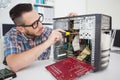 Computer engineer working on broken console with screwdriver Royalty Free Stock Photo