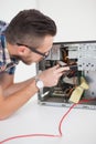 Computer engineer working on broken console with screwdriver Royalty Free Stock Photo
