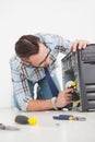 Computer engineer working on broken console with screwdriver Royalty Free Stock Photo