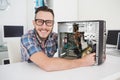 Computer engineer working on broken console smiling at camera Royalty Free Stock Photo