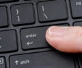 Computer enter key with finger pressing button Royalty Free Stock Photo