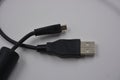 Computer equipment, a long, black micro USB cable from a digital camera to a regular computer. Royalty Free Stock Photo