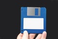 Computer floppy disk in Hand on black background. Royalty Free Stock Photo
