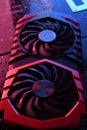 Computer game graphics card, videocard with two coolers on circuit board ,motherboard background. Close-up. With red-blue lighting Royalty Free Stock Photo