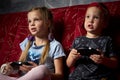 Computer games: a boy and a girl play a game console in the dark and hold gamepads in their hands. Royalty Free Stock Photo