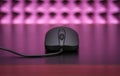 Computer gaming mouse on a table on a pink studio background Royalty Free Stock Photo