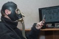 At the computer in a gas mask in a nuclear explosion. Concept of bacteriological safety, radiation and chemical protection Royalty Free Stock Photo