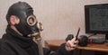 At the computer in a gas mask in a nuclear explosion. Concept of bacteriological safety, radiation and chemical protection Royalty Free Stock Photo