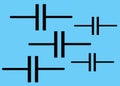 Five fixed capacitor electrical symbols against a light blue turquoise backdrop