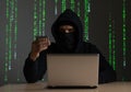 Computer hacker with credit card stealing data from a laptop concept for network security, identity theft and computer Royalty Free Stock Photo