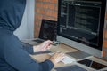 Computer hacker or cyber attack concept, Dangerous hooded hacker using multiple computers typing bad data into online system the Royalty Free Stock Photo