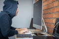 Computer hacker or cyber attack concept, Dangerous hooded hacker using multiple computers typing bad data into online system the Royalty Free Stock Photo