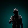 Computer hacker in hoodie. Obscured dark face. Data thief, internet fraud, darknet and cyber security concept.