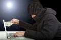 Computer hacker stealing money in the darkness