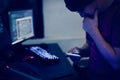 Computer hacker using mobile in dark room Royalty Free Stock Photo