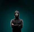 Computer hacker in white mask and hoodie. Obscured dark face. Data thief, internet fraud, darknet and cyber security Royalty Free Stock Photo