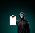 Computer hacker in white mask and hoodie. Obscured dark face. Data thief, internet fraud, darknet and cyber security Royalty Free Stock Photo