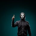 Computer hacker in white mask and hoodie. Obscured dark face. Data thief, internet fraud, darknet and cyber security Royalty Free Stock Photo