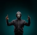 Computer hacker in white mask and hoodie. Obscured dark face. Data thief, internet fraud, darknet and cyber security