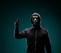 Computer hacker in white mask and hoodie. Obscured dark face. Data thief, internet fraud, darknet and cyber security Royalty Free Stock Photo