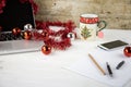 Computer job at Christmas holidays concept: light wooden table with an open aluminum laptop, red decoration, red baubles, Royalty Free Stock Photo