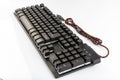 Computer keyboard. Black keyboard with a cord on a white background Royalty Free Stock Photo