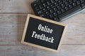 computer keyboard and blackboard on wooden background. Online feedback. Royalty Free Stock Photo