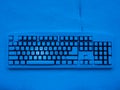 Computer keyboard covered with snow illuminated by blue neon light with text merry christmas Royalty Free Stock Photo