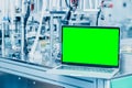 Computer laptop blank green screen on science lab advance machine automation engineering tech industry concept background