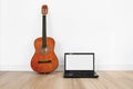 Computer laptop, blank white screen with acoustic guitar Royalty Free Stock Photo