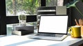 Laptop, books, coffee cup and potted plant on white table. Blank screen for your text message or information content. Royalty Free Stock Photo