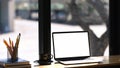 Laptop with empty screen, coffee cup, stationery and books on wooden table. Royalty Free Stock Photo