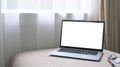 Laptop with empty screen on comfortable sofa in bright living room. Royalty Free Stock Photo