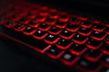 Computer laptop keyboard with red dark backlight, backlit in the dark. Concept computer keyboard background. Royalty Free Stock Photo