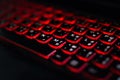 Computer laptop keyboard with red dark backlight, backlit in the dark. Concept computer keyboard background. Royalty Free Stock Photo