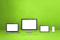 Computer, laptop, mobile phone and digital tablet pc. green background Royalty Free Stock Photo