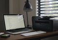 Modern Home Office Setup with Laptop Printer and Desk Lamp Royalty Free Stock Photo