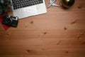 Computer laptop, retro camera, airplane and coffee cup on wooden background.