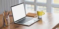 Computer laptop with white blank screen putting on wooden working desk. Royalty Free Stock Photo