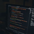 A computer monitor displays coding syntax in a text editor. The screen features lines Royalty Free Stock Photo