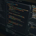 A computer monitor displays multiple lines of colorful code in a dark-themed code Royalty Free Stock Photo