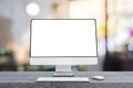 Computer monitor with wireless mouse and keyboard over blurred vintage office Royalty Free Stock Photo