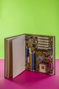 Computer motherboard in a large open book on a colored background Royalty Free Stock Photo