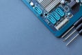 Computer motherboard and three small screwdrivers on a gray paper background with copy space