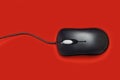 Computer mouse black on a red background. Close-up Royalty Free Stock Photo